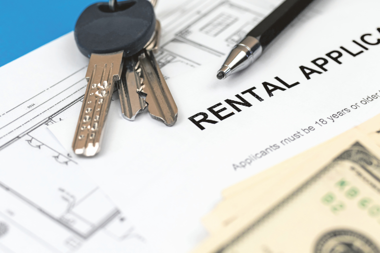 Rental agreement document on office table. Pen, house keys and money closeup